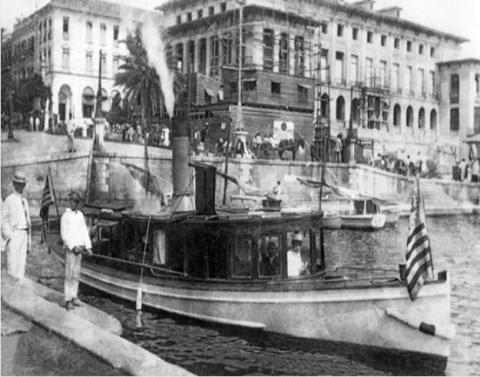 Customs cutter leaves the dock at the U.S. Custom House in San Juan, Puerto Rico. In the background is the U.S. Post Office then under construction.