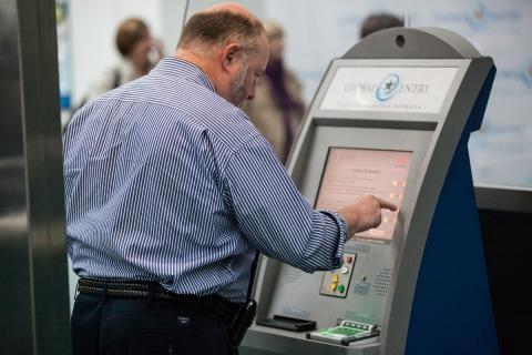 An arriving passenger at Newark [N.J.] Liberty International Airport uses a Global Entry kiosk to enter the U.S. (photo by Josh Denmark)