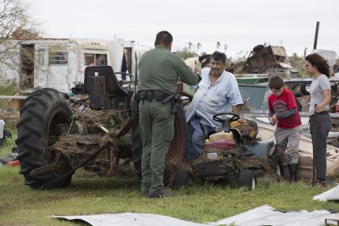 U.S Border Patrol agent Mario Fuentes talks with a family after Hurricane Harvey 