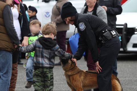 Young child petting a CBP canine.