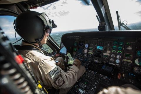 A CBP Air Interdiction Agent patrols in a Black Hawk helicopter.