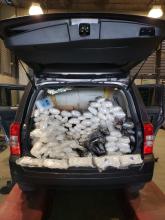 Narcotics displayed in the rear of a black SUV type vehicle.