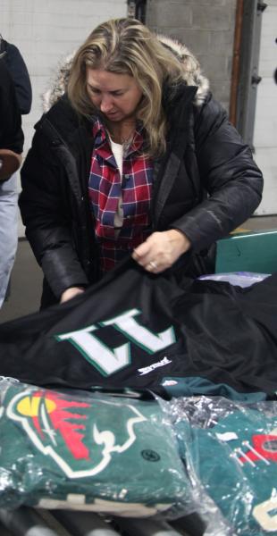 Helene Warren-Cutler, a senior import specialist with more than 30 years’ experience sent from Philadelphia as part of CBP’s Apparel, Footwear and Textile Center of Excellence and Expertise, inspects a counterfeit Philadelphia Eagles jersey during an inspection at an express consignment carrier facility near Minneapolis, Minnesota. Photo by Glenn Fawcett