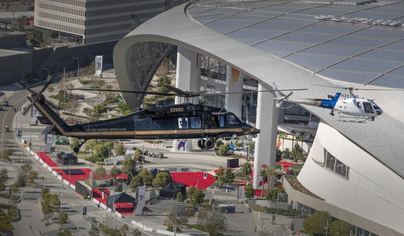 Two AMO helicopters pass by the Super Bowl stadium.