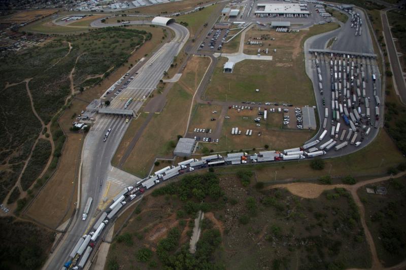 A U.S. port of entry with vehicles and trucks waiting to enter.