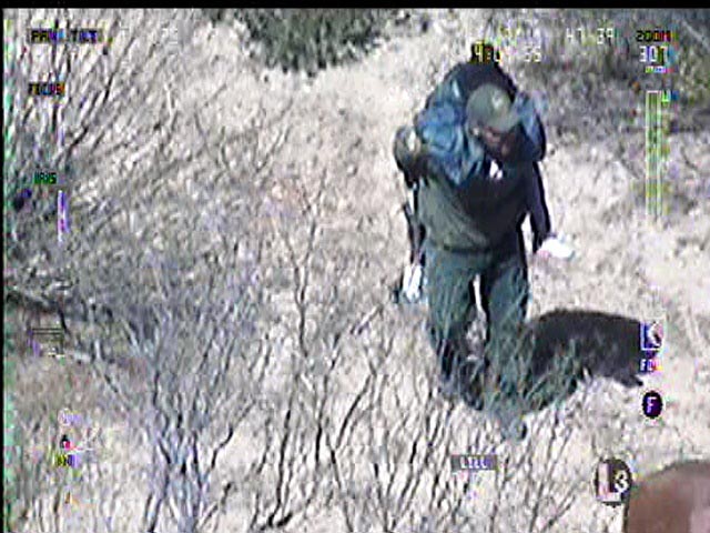 A U.S. Border Patrol agent carries a distressed child to safety on his back