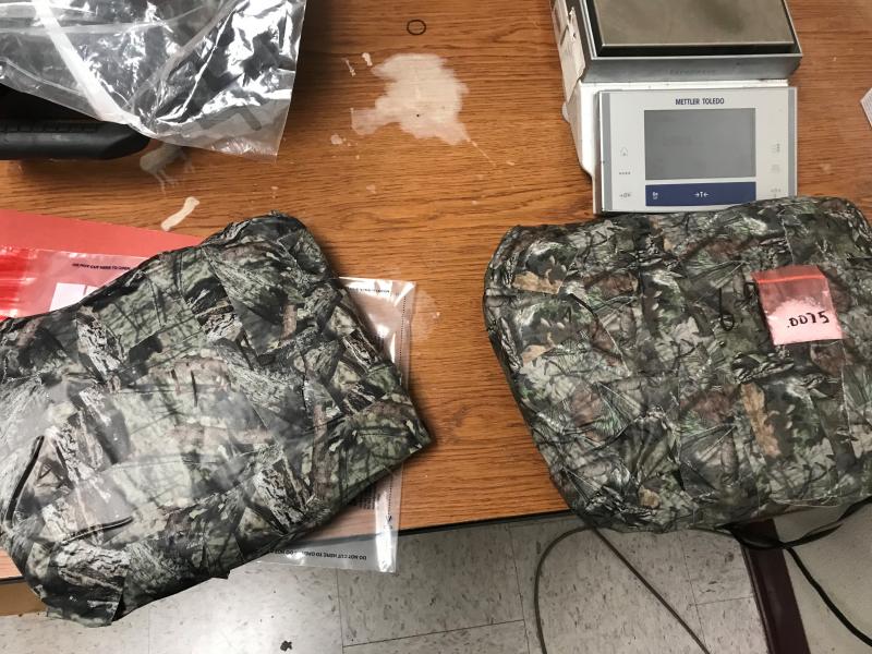 A search of the vehicle revealed two packages hidden under the vehicle’s front seats.  The bundles were wrapped in camouflage duct tape in attempt to further conceal the packages from view.  