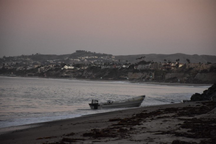 A panga style boat used for smuggling sits in the surf off a beach near San Mateo Point. 