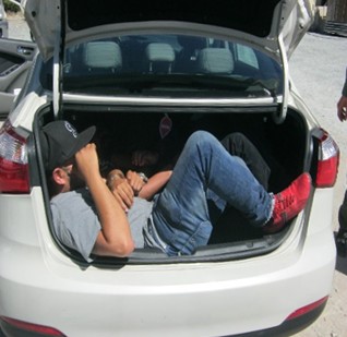 Agents arrested a man who was smuggling three people in the trunk of his car.