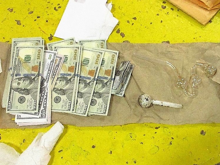 Officers removed an envelope with $5,000 in counterfeit currency as well as drug paraphernalia
