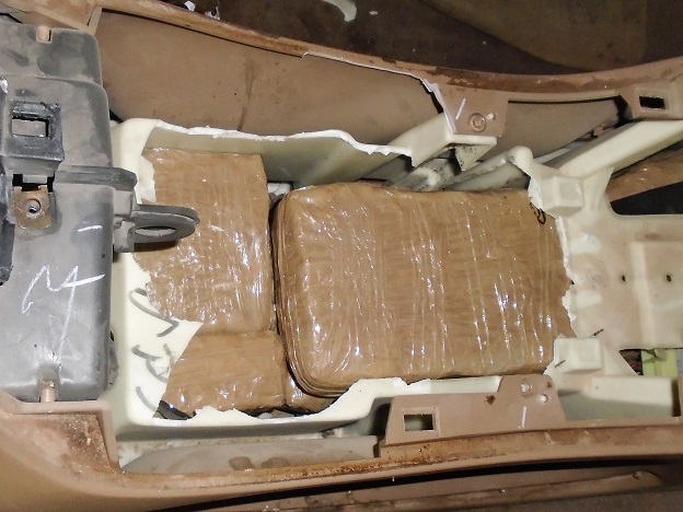 Officers discovered packages of marijuana beneath the center console of a smuggling vehicle