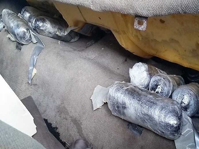 Officers discovered packages of meth beneath the seats of a smuggling vehicle