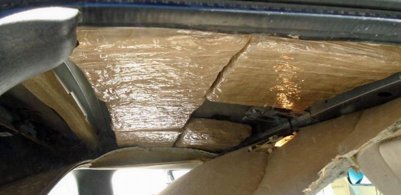 Officers removed packages of marijuana from within the headliner of a smuggling vehicle