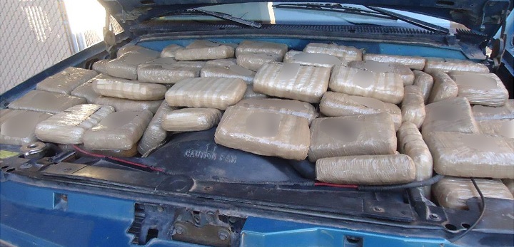 Officers discovered packages of marijuana beneath the hood of a smuggling vehicle 