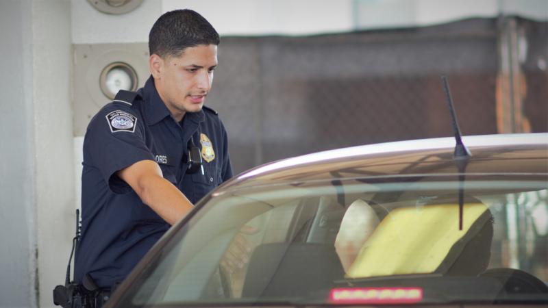 A CBP officer conducts a vehicle priamry examination at Juarez-Lincoln Bridge