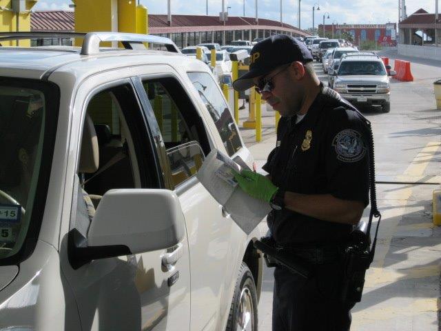 A CBP offidcer conducts a primary inspection at Progreso International Bridge