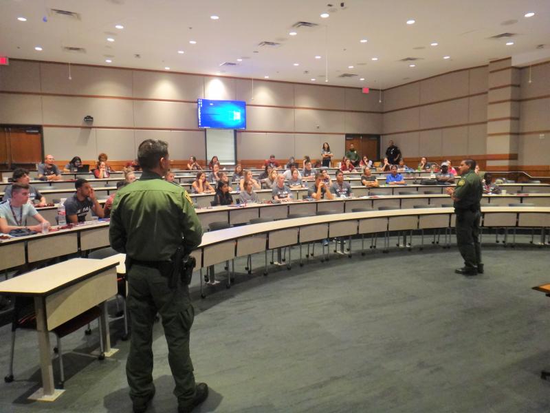 Border Patrol agents provide presentation regarding document requirements and responsibilities for maintaining student status to a group of internationla students at TExas A&M International University
