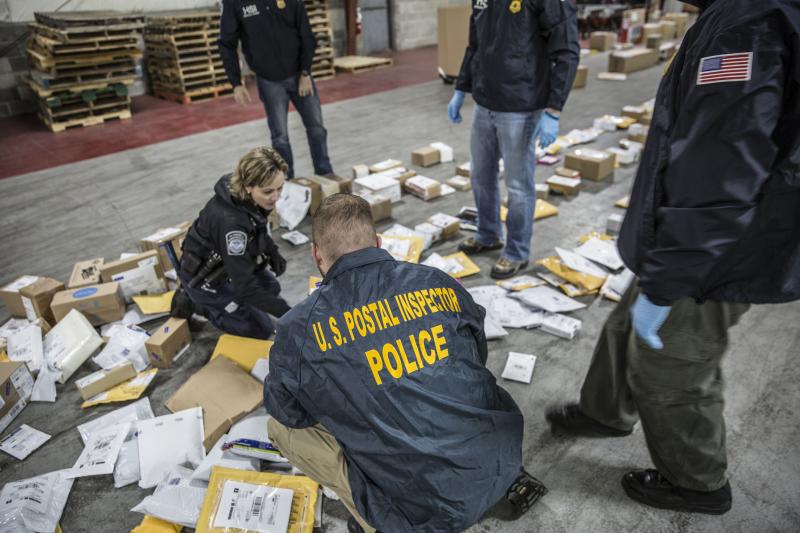 Global Trade Task Force members sort through a mail facilty during Operation Alliance
