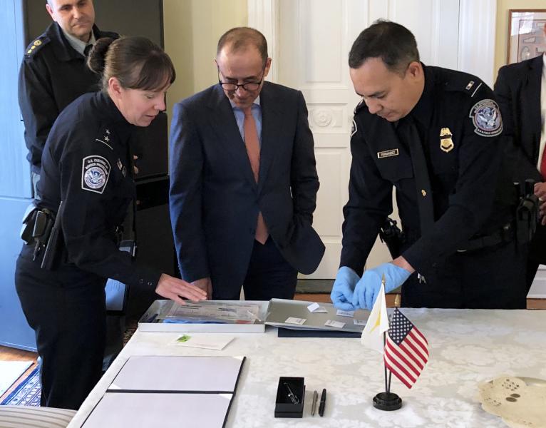 Casey Durst, U.S. Customs and Border Protection, Director of Field Operations, Baltimore Field Office presents seven ancient coins to Cyprus Ambassador Marios Lyssiotis during a repatriation ceremony at the Cyprus Embassy in Washington, D.C., February 14, 2020.