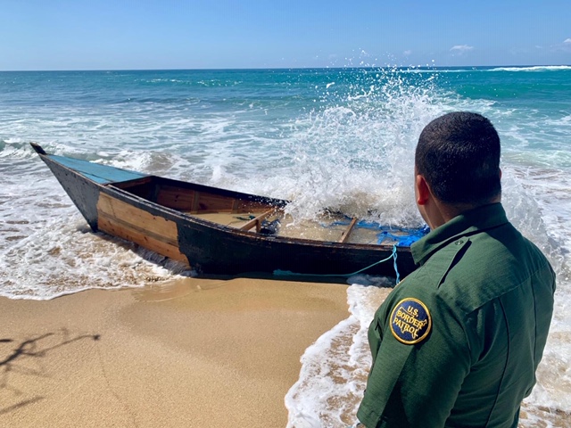 A Border Patrol Agent examines a "yola" type vessel that was abandoned in western Puerto Rico