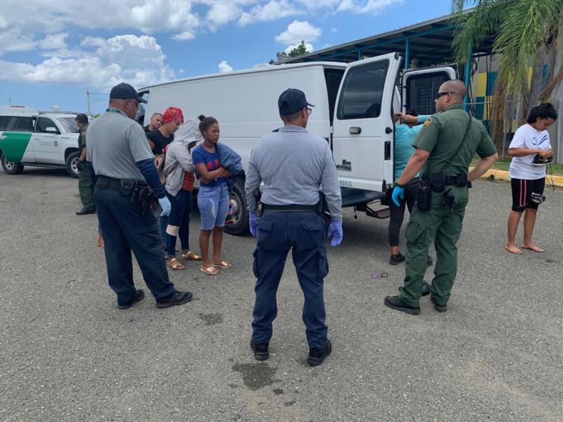 Border Patrol and municipal police assist female aliens before boarding vehicles to the station. 