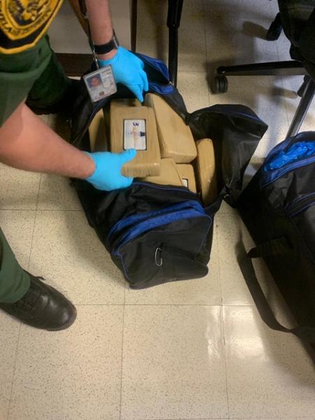 A cocaine  brick is taken out from the bags  seized. 