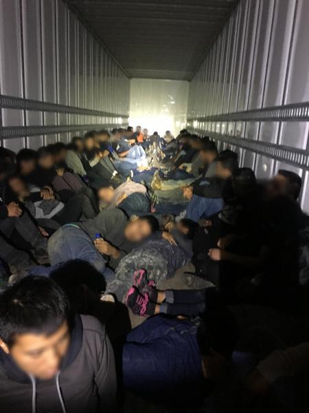 Migrantes extranjeros encerrados en un contenedor
