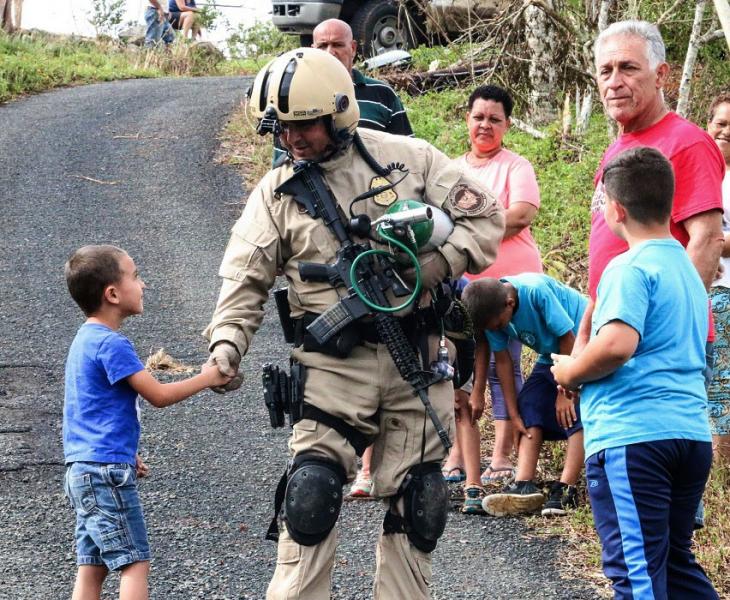 An AMO agent greets a child while delivering supplies to those impacted by Hurricane Maria
