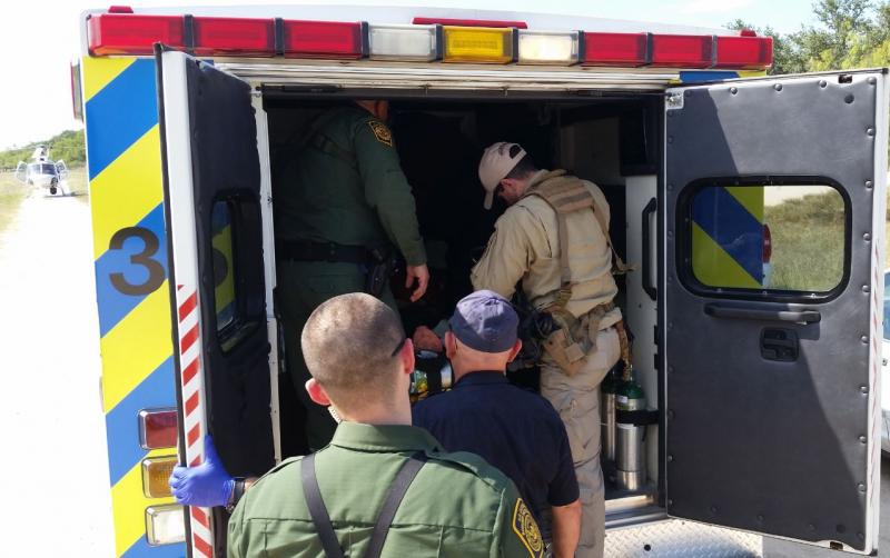 Agents from Border Patrol and Air and Marine Operations help subject into ambulance