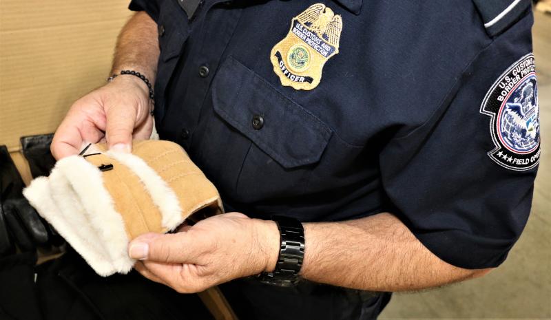 A CBP Officer at the LA/LB Seaport inspects a shipment of leather gloves suspected to have been made with forced labor in Xinjiang, China.