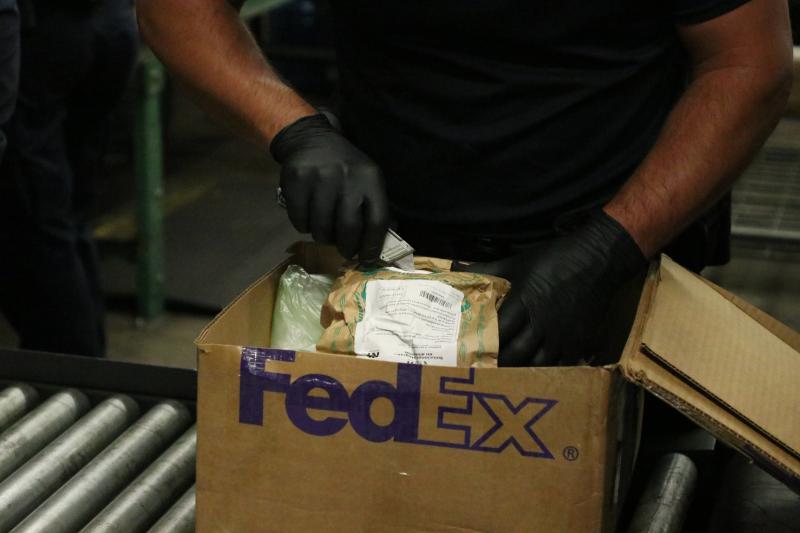 CBPO cuts into a bag of white powder at the Memphis airport